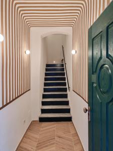 a hallway with stairs with a striped ceiling at Il Caruggio Townhouse in Varazze