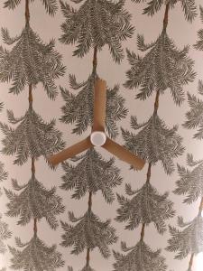 a ceiling fan hanging from a wall with christmas trees at Il Caruggio Townhouse in Varazze