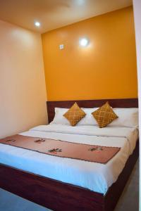 a bedroom with a bed with yellow walls at Hotel Sawai View in Sawāi Mādhopur