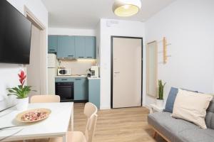 a kitchen and living room with a table and a couch at Samà Housing in Larisa