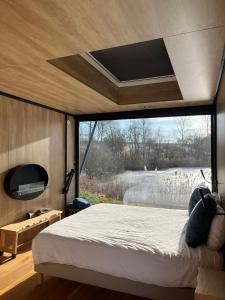 a bedroom with a bed and a large window at Bleu Minuit La Rive Etoilée in Thézillieu
