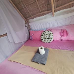 a bed in a tent with a roll of toilet paper at Island Crib in El Nido
