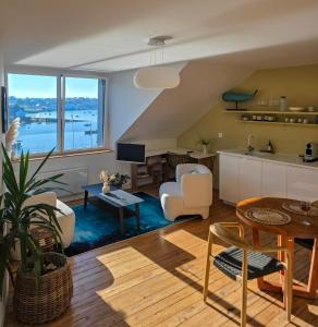 an open living room with a kitchen and a living room at Anatoline - Appart'hotel vue mer - Sea View Apartments - Audierne in Audierne