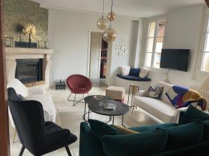 a living room with white furniture and a fireplace at Les bulles lissoises in Lisse