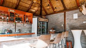 a woman sitting at a bar in a restaurant at Falcon Lodge PK in Bela-Bela