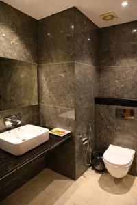 a bathroom with a sink and a toilet at Hotel Sahil Suites in Katra +8 photos
