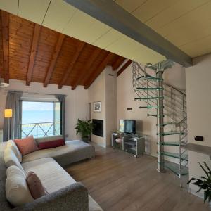 a living room with a couch and a spiral staircase at FilandaLago apartment in Iseo