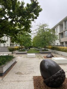 a courtyard with a large black sculpture in front of a building at Instellies Andringa Walk Apartment in Stellenbosch