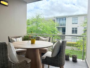 a patio with a table and chairs on a balcony at Instellies Andringa Walk Apartment in Stellenbosch