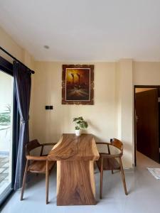 a living room with a wooden table and chairs at Alena in Nusa Dua
