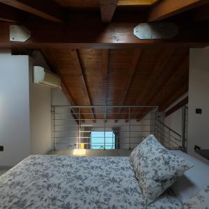a bedroom with a bed with a wooden ceiling at FilandaLago apartment in Iseo