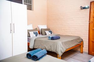 two beds in a room with blue towels on them at Falcon Lodge PK in Bela-Bela +12 photos