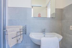 ein Badezimmer mit Waschbecken, Spiegel und Handtüchern in der Unterkunft White Room "Dimore Lucane" in Ruoti + 34 Fotos