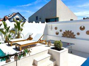 a rooftop patio with furniture and a swimming pool at Villa Rafa in Costa Nova