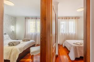 a bedroom with two beds and a mirror at BoLina Ocean View in Caniço