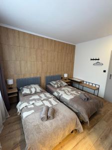 two beds in a room with wooden floors at Villa Gold Poznań in Poznań