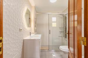 a white bathroom with a sink and a shower at BoLina Ocean View in Caniço +29 photos