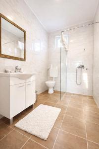a bathroom with a sink and a shower and a toilet at Apartmani Sun & Moon in Žepče