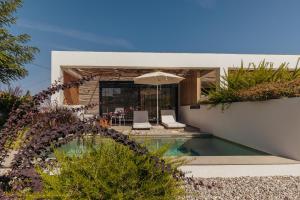 a villa with a swimming pool and a house at Acacia - Explore your senses in Preveza