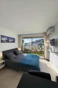 a bedroom with a bed and a large window at Studio Premium au Calme avec Terrasse Vue Mer et Parking in Nice