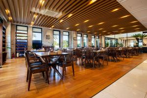 a restaurant with wooden tables and chairs and windows at Libentia Hotel & Poolvilla in Jeju