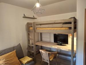 a room with a bunk bed and a desk with a tv at La Source in La Croix-Saint-Leufroy
