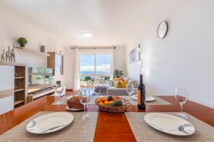 a dining room with a table with a bowl of fruit at BoLina Ocean View in Caniço