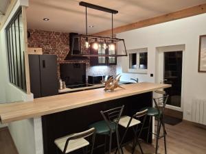 a kitchen with a bar with stools and a counter top at La Source in La Croix-Saint-Leufroy