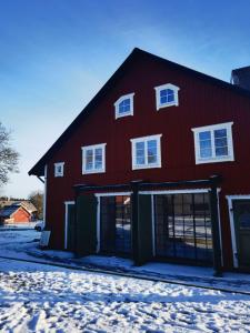 a red house with a garage in the snow at Farm under the stars in Vallentuna