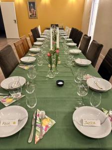 a long table with plates and wine glasses on it at Farm under the stars in Vallentuna