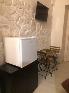 a white refrigerator sitting on top of a counter with a table at B&B Santa Chiara Home in Caserta +30 photos