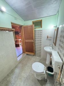 a bathroom with a toilet and a sink at Hotel Sumit in Kausani +56 photos
