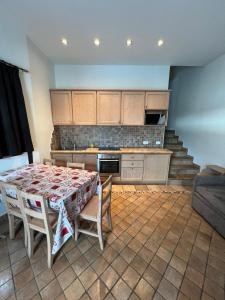 a kitchen with a table and chairs and a kitchen with stairs at Chalet Rin da Pemont in Livigno