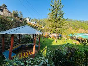 a gazebo with a table and chairs in a yard at Hotel Sumit in Kausani
