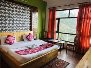 a bedroom with a large bed with pink pillows at Hotel Sumit in Kausani