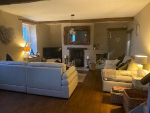 a living room with a white couch and a living room with a fireplace at The Hideaway Embleton in Embleton