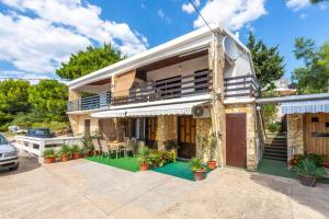 a house with a porch and a patio at Apartmani Danijela in Stara Novalja