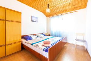 a bedroom with a bed and a table and a chair at Apartmani Danijela in Stara Novalja