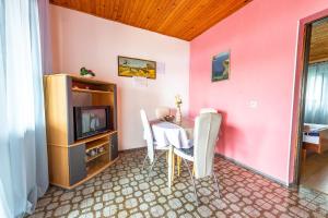a dining room with a table and a tv at Apartmani Danijela in Stara Novalja