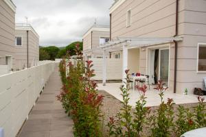 a walkway between two buildings with plants at Margidore Beach in Lacona