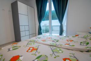 a bedroom with a bed with a comforter and a window at Margidore Beach in Lacona
