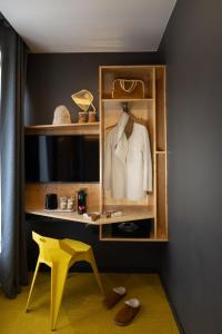 a shelf with a white shirt and a yellow chair at Urban Bivouac Hotel in Paris