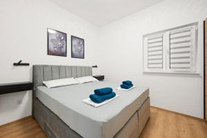 a white bedroom with a large bed with blue towels on it at House Villa Zvonko Near NP Krka in Sedramić +28 photos
