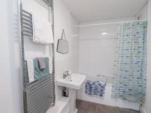 a white bathroom with a sink and a shower curtain at 1 Castle Terrace in Thirsk +21 photos