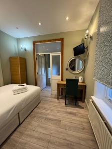 a bedroom with a bed and a desk and a mirror at The Paramount Hotel in London