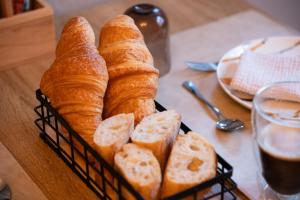 a basket of bread on a table with a glass of beer at Rêve Champenois Chambres d'Hôtes in Rilly-la-Montagne