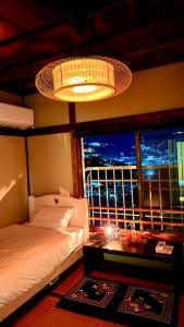 a bedroom with a bed and a table and a window at Grace House Hill Paradise Atami in Atami