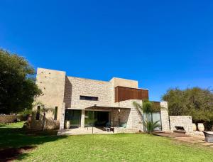 a large brick house with a grass yard at Villa Terra Akal in Essaouira