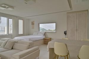 a bedroom with two beds and a couch and a table at 레이니데이 in Namŭm-ni +119 photos