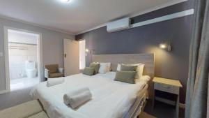 a bedroom with a large white bed and a window at Portview and Brenwin Guesthouse in Cape Town +24 photos